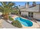 Backyard featuring a kidney-shaped pool surrounded by a concrete patio, landscaping and lounge chairs at 841 Rusty Anchor Way, Henderson, NV 89002