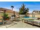 Outdoor living features a covered patio, BBQ area, swimming pool and seating area in a fenced yard at 947 Rainbow Rock St, Las Vegas, NV 89123