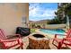 Inviting backyard featuring a stone fire pit, pool, and lush landscaping for outdoor relaxation and enjoyment at 947 Rainbow Rock St, Las Vegas, NV 89123