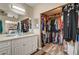 Dual sink vanity in bathroom features a walk-in closet with custom shelving and storage for clothing and accessories at 947 Rainbow Rock St, Las Vegas, NV 89123