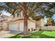 Well maintained two-story home with a large tree, lawn and three-car garage at 947 Rainbow Rock St, Las Vegas, NV 89123
