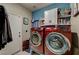 Bright laundry room boasts red front-loading washer and dryer and convenient shelving at 947 Rainbow Rock St, Las Vegas, NV 89123