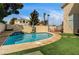 Inviting swimming pool with waterfall feature, surrounded by lush grass and a paved patio; perfect for summer fun at 947 Rainbow Rock St, Las Vegas, NV 89123