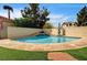 Beautiful pool with a step waterfall feature, surrounded by artificial turf and block wall providing ultimate privacy at 947 Rainbow Rock St, Las Vegas, NV 89123