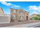Charming two-story home with tan stucco, low brick wall and an arched entry at 963 Sable Chase Pl, Henderson, NV 89011
