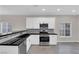 Modern kitchen featuring stainless steel appliances, sleek granite countertops, and ample lighting at 963 Sable Chase Pl, Henderson, NV 89011