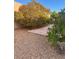 Home's backyard featuring gravel landscaping and mature flowering trees at 9731 Addie Meadow Ct, Las Vegas, NV 89149