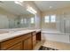 Bathroom featuring double sinks, granite countertops, separate shower and a relaxing soaking tub at 9731 Addie Meadow Ct, Las Vegas, NV 89149