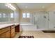 Bright bathroom featuring granite countertops, a soaking tub, and a glass enclosed shower at 9731 Addie Meadow Ct, Las Vegas, NV 89149