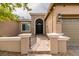 Close-up view of a home's entry featuring a decorative stone archway and manicured landscaping at 9731 Addie Meadow Ct, Las Vegas, NV 89149
