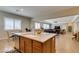 Open kitchen with island seating area overlooks living spaces with great light and warm design touches at 9731 Addie Meadow Ct, Las Vegas, NV 89149
