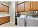 Functional laundry room featuring a sink, ample cabinet space, and modern washer and dryer at 9731 Addie Meadow Ct, Las Vegas, NV 89149