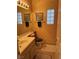 Bathroom featuring a sink, toilet, and glass block windows, showcasing a clean and functional space at 976 Dancing Vines Ave, Las Vegas, NV 89183