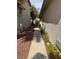 View of concrete walkway between two homes with gravel and plant groundcover leading to a black metal gate at 976 Dancing Vines Ave, Las Vegas, NV 89183