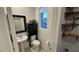 Cozy powder room with pedestal sink, dark wood accents, and storage cabinet with a view to the outdoors at 1027 Brilliant Meadow Ave, North Las Vegas, NV 89086