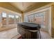 Sunroom featuring a covered hot tub, tile flooring, and multiple windows for natural light at 10505 Linden Wood Ct, Las Vegas, NV 89134