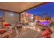 Inviting covered patio with a stone fireplace, seating, and view of the pool and spa at 11072 Pentland Downs St, Las Vegas, NV 89141