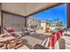 Comfortable covered back patio area with a stone fireplace and view of the pool and palm trees at 11072 Pentland Downs St, Las Vegas, NV 89141