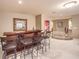Finished basement bar with dark wood, decorative mirror, and seating for entertaining at 11072 Pentland Downs St, Las Vegas, NV 89141
