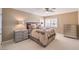 Comfortable bedroom with neutral tones, a ceiling fan, and bright, shuttered windows at 11072 Pentland Downs St, Las Vegas, NV 89141