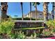 Royal Highlands community entrance with lush landscaping, colorful flowers, and palm trees under a blue sky at 11072 Pentland Downs St, Las Vegas, NV 89141