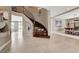 Elegant foyer with curved staircase, tile flooring, and access to multiple living areas at 11072 Pentland Downs St, Las Vegas, NV 89141
