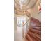 Elegant grand foyer with curved staircase, hardwood steps, and a decorative chandelier at 11072 Pentland Downs St, Las Vegas, NV 89141