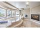 Luxurious main bathroom featuring a soaking tub, fireplace, and large windows at 11072 Pentland Downs St, Las Vegas, NV 89141