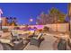 Beautiful backyard patio featuring an outdoor dining area, lounge chairs, and a custom rock pool waterfall at 11072 Pentland Downs St, Las Vegas, NV 89141