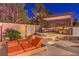 Inviting backyard patio with a covered outdoor lounge, sun loungers, and well-manicured tropical landscaping at 11072 Pentland Downs St, Las Vegas, NV 89141