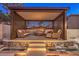Outdoor pergola with comfortable seating area and a stone fireplace feature at 11072 Pentland Downs St, Las Vegas, NV 89141