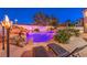 Luxury outdoor pool area with rock waterfall, lush landscaping, and comfortable lounge chairs for relaxing at 11072 Pentland Downs St, Las Vegas, NV 89141