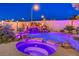 Custom pool with rock waterfall feature, built-in spa, and vibrant LED lighting for evening enjoyment at 11072 Pentland Downs St, Las Vegas, NV 89141