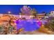 A relaxing backyard oasis featuring a custom pool with a rock waterfall and colorful lighting at 11072 Pentland Downs St, Las Vegas, NV 89141