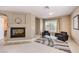 Cozy sitting room with a fireplace, comfortable seating, and a bright window, perfect for relaxation at 11072 Pentland Downs St, Las Vegas, NV 89141