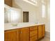 Bathroom featuring a double vanity, large mirror and oak cabinets at 11204 Newbury Hills Ave, Las Vegas, NV 89138