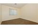 An empty bedroom with carpeted floors and a large window providing lots of natural light at 11204 Newbury Hills Ave, Las Vegas, NV 89138