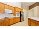 Well-lit kitchen showcasing wooden cabinetry, modern stainless steel appliances, and a white countertop island at 11204 Newbury Hills Ave, Las Vegas, NV 89138