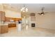 Open floor plan with fireplace, ceiling fan, and kitchen view with island at 11204 Newbury Hills Ave, Las Vegas, NV 89138