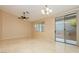 A bright living room with tile floors, a ceiling fan and a glass door leading to the outside at 11204 Newbury Hills Ave, Las Vegas, NV 89138