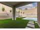 Covered patio with artificial grass and a backyard pool at 12346 Valley Chase Ave, Las Vegas, NV 89138