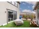Backyard with artificial grass and sliding glass doors leading to the interior at 12346 Valley Chase Ave, Las Vegas, NV 89138