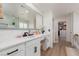 Bright bathroom with white cabinets, black hardware, quartz counters, and a large framed mirror at 12346 Valley Chase Ave, Las Vegas, NV 89138
