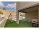 Covered patio with a grill and swing near a beautiful backyard pool at 12346 Valley Chase Ave, Las Vegas, NV 89138
