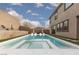 Backyard pool and spa with a tanning ledge, lounge chairs, and artificial grass at 12346 Valley Chase Ave, Las Vegas, NV 89138