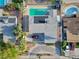 Aerial shot featuring a backyard pool, solar panels, and a driveway with ample parking surrounded by lush greenery at 1589 Silver Mesa Way, Las Vegas, NV 89169