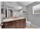 Bathroom featuring double sinks, dark wood cabinets, a large mirror, and tiled floors at 1606 Wild Grain Ave, North Las Vegas, NV 89086