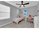 Cozy bedroom featuring a bed, desk, chair, ceiling fan and natural light from a window at 1606 Wild Grain Ave, North Las Vegas, NV 89086