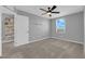 Bright bedroom featuring neutral walls, carpet flooring, a ceiling fan, and a shelved closet at 1606 Wild Grain Ave, North Las Vegas, NV 89086