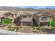 Two-story home featuring desert landscaping, a two-car garage and brick paved driveway at 1606 Wild Grain Ave, North Las Vegas, NV 89086